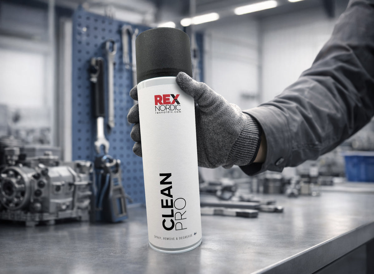 Gloved hand picking up REX CleanPro degreaser in a workshop