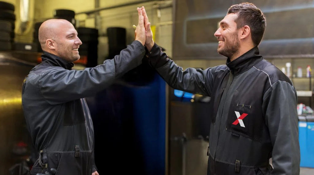 auto mechanics making high five at car shop