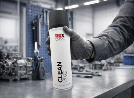 Gloved hand picking up REX CleanPro degreaser in a workshop