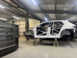 Rally car in a workshop where Airrex heater is keeping the space warm.