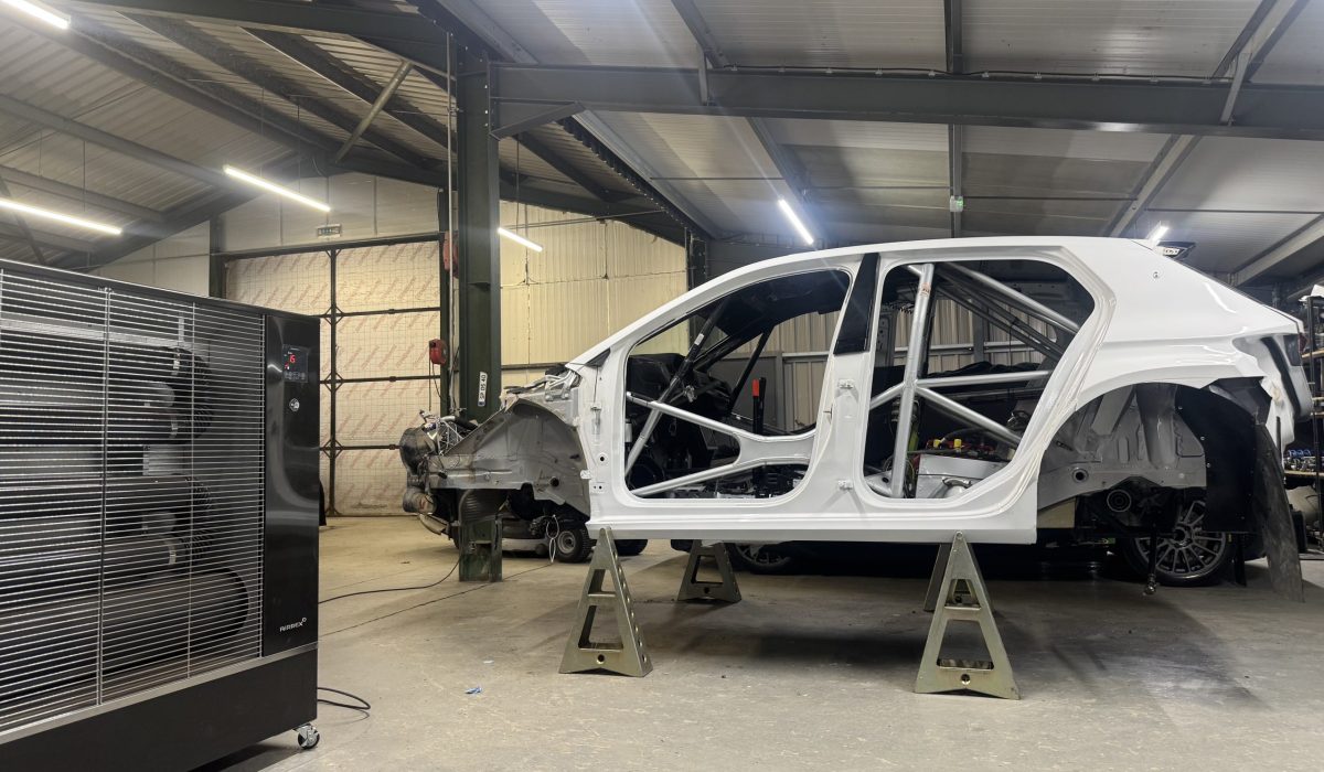 Rally car in a workshop where Airrex heater is keeping the space warm.
